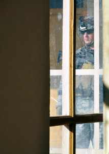 Slaten in uniform through a building window.