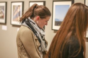 Junior Mary Wentzel examines one of the 47 photos on March 4 in Roberta’s Art Gallery in the University Center. 