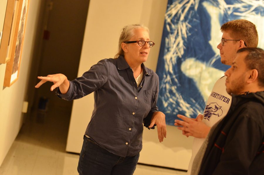 Susan Messer explains her pinhole camera photograph prints to student Cody Reibold and friend at the ‘in Light We Trust’ exhibit reception held in the Crossman Gallery. 