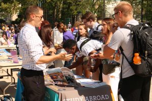  Students crowd around a exhibitor table at the Global Experience Fair. The event gave students information about how to finance a trip abroad, along with managing credits and classes to guarantee on-time graduation and other visa and health-related matters. Photo by Zach Ewoldt. 
