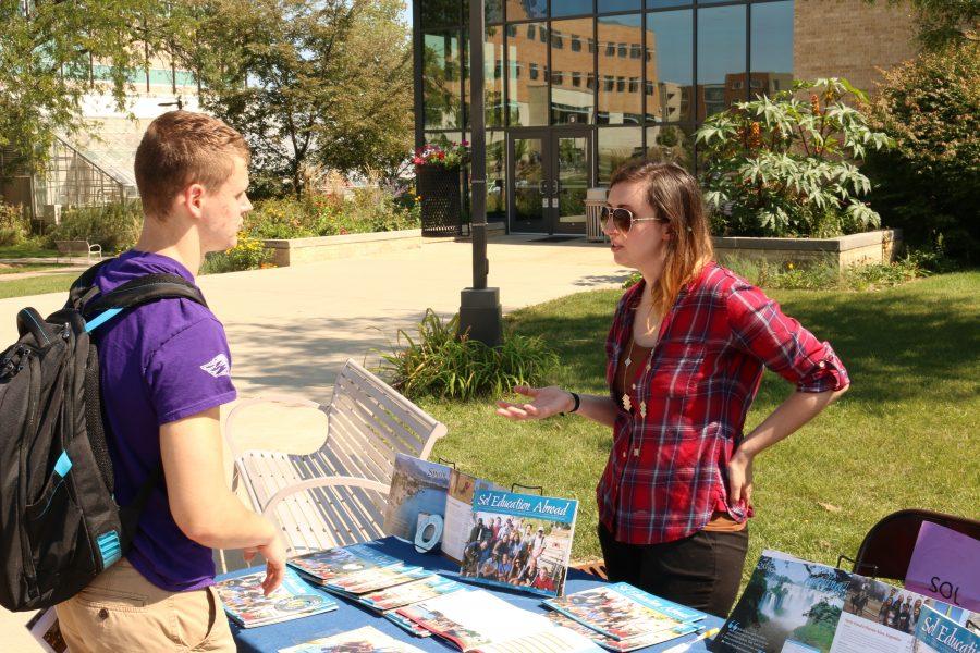 Freshman Zach Galvin talks to an exhibitor about pursuing an education abroad. The Global Experience featured 55 exhibitors along the Wyman Mall between Hyland Hall and the University Center. Photo by Zach Ewoldt.
