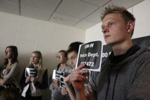 Freshman Jordan Haskin holds up a booking number in the African-American experiences room at Boxes and Walls on Oct. 12.