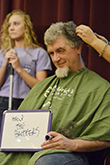 Kappa Epsilon alumni Joe Neterval smiles while chopping his hair to benefit childhood cancer.