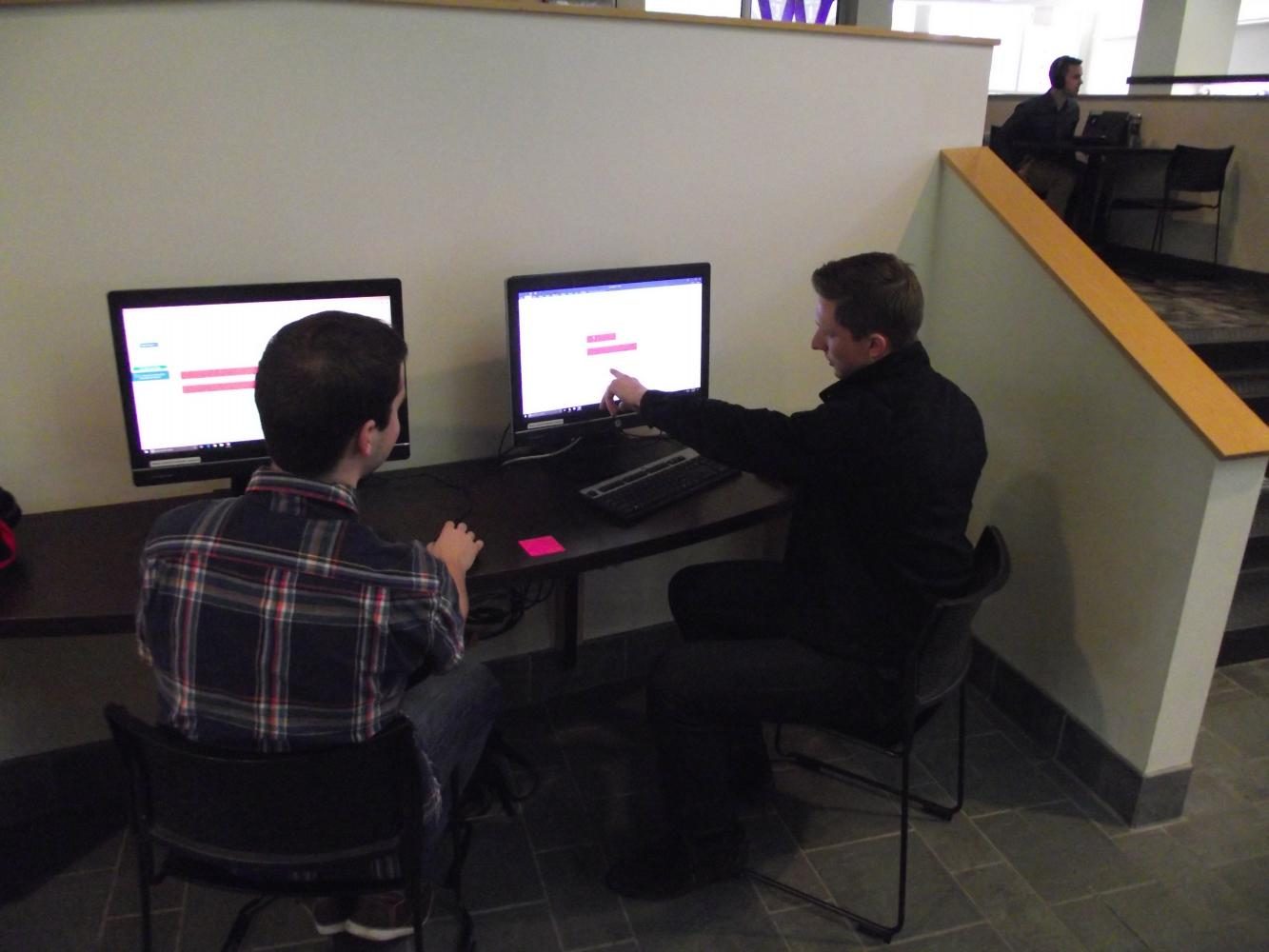 Seniors Jacques LaReau and Trevor Beckmann sift through vaccination research together in the UC. 