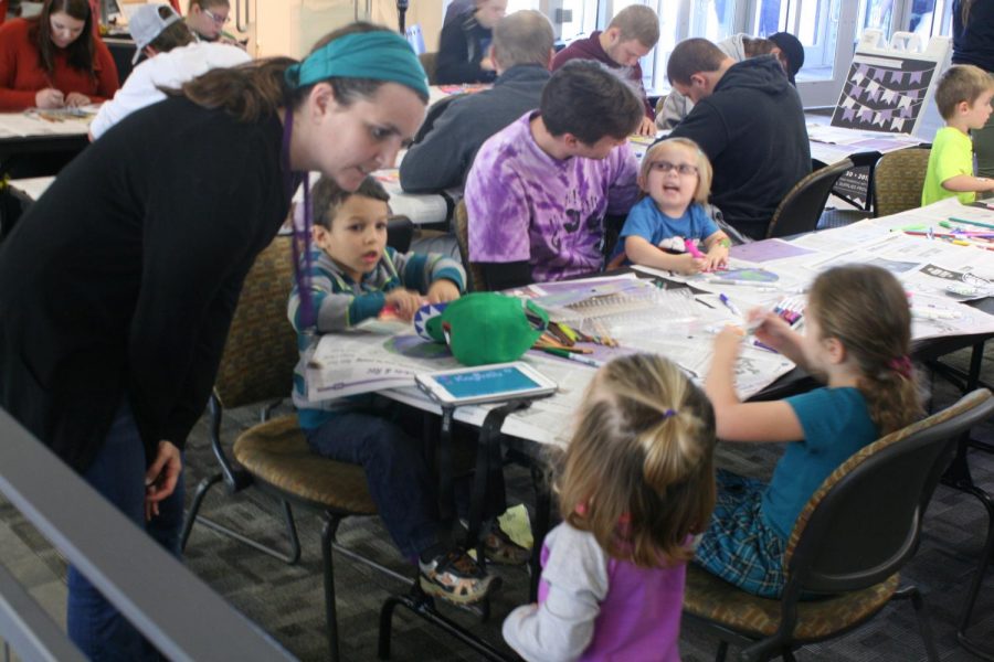 Jenna Kenny, lead 4-K teacher at the Children’s Center pre-school program, instructs a group of her students on how to create colorful art in the shape of butterflies Monday at a Divsersity Week event.