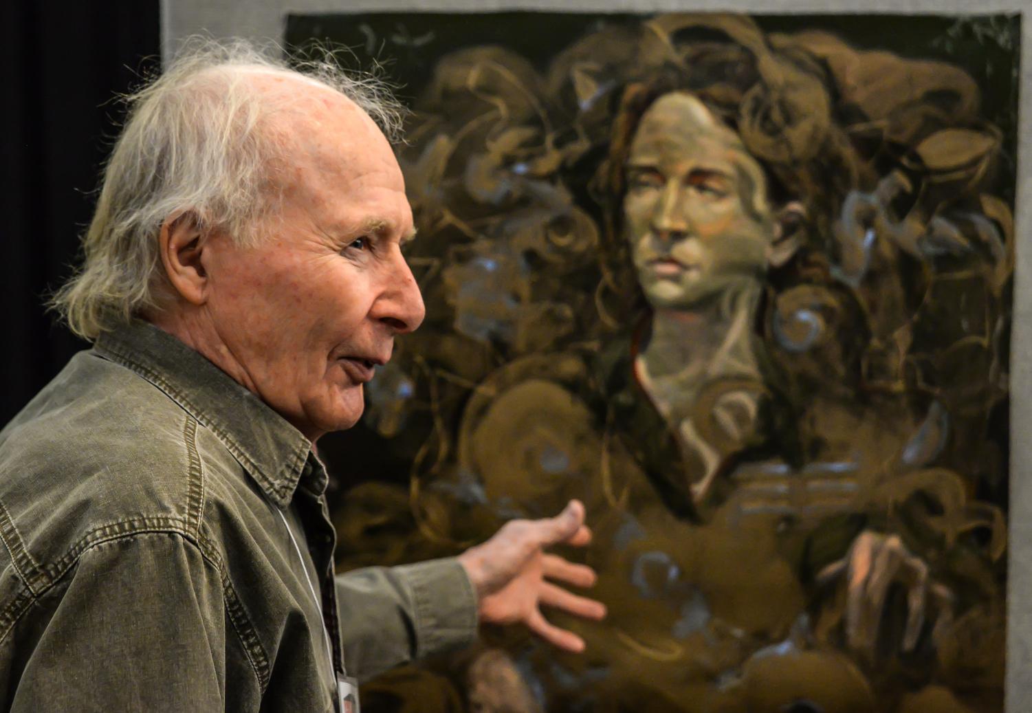 Artist Jason Miklik describes his process behind his portrait paintings at an exhibit feature his artwork in the Whitewater Cultural Arts Center.