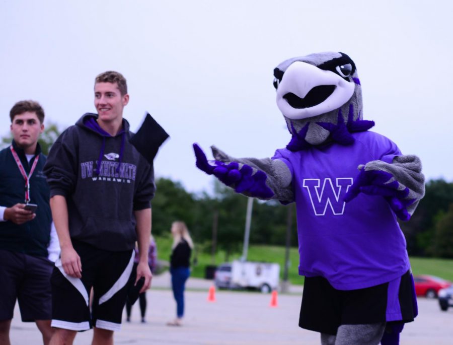Willie the Warhawk plays a bag toss game with students and community members at his Birthday Bash. 