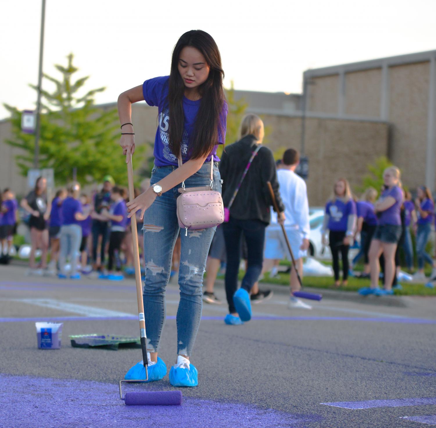 Freshman Rina Tsumuraya applies a fresh coat of purple to Warhawk Drive as a part of the fall orientation process.
