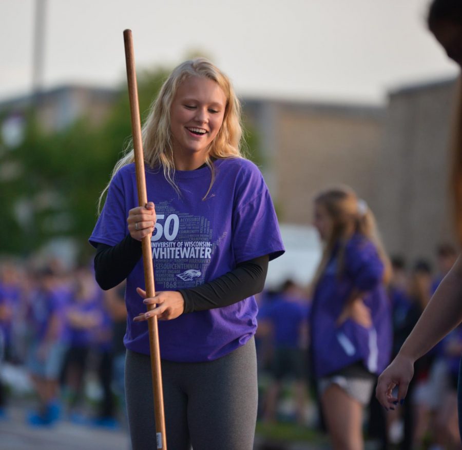 Freshman, Sadie Driscoll paints the pavement purple during Warhawk Welcome