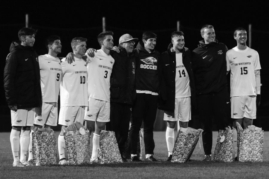 Warhawk seniors pose with coach Guinn to commemorate Senior Night.