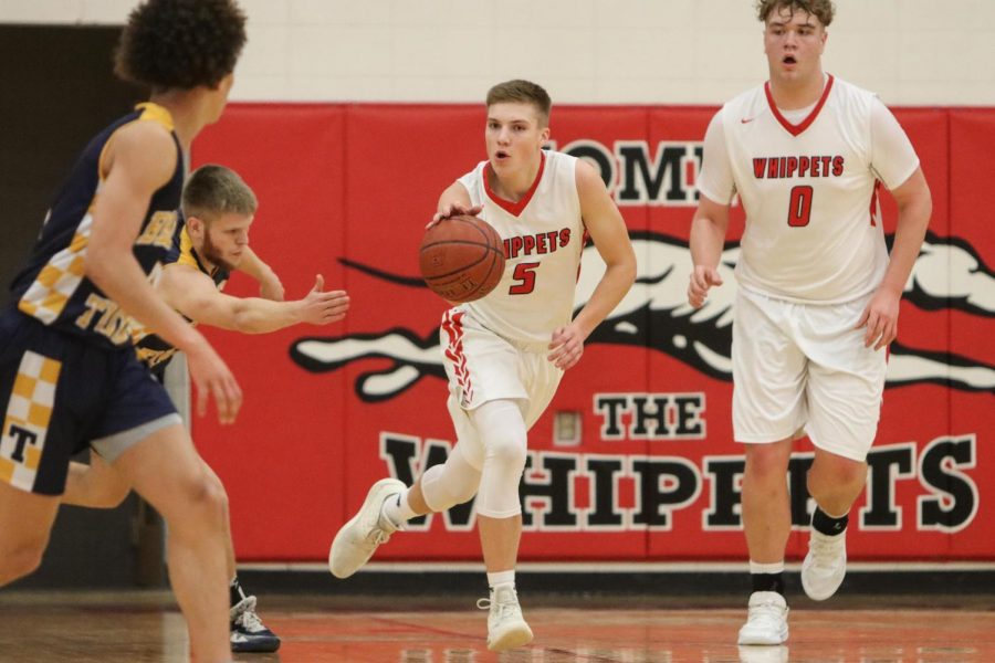 Brock Grosinske (5) brings the ball up the court in front of Jake Martin (0) against Turner on Tuesday at home. Martin finished with 19 points. 