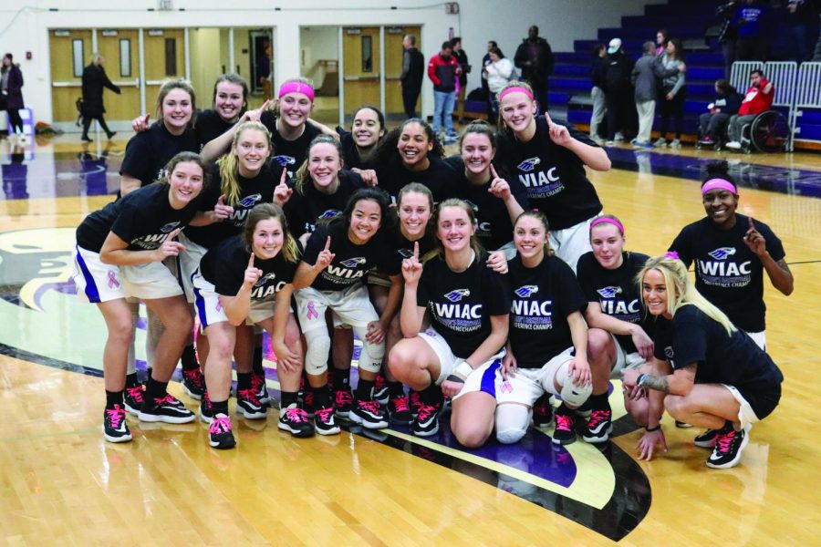 The womens basketball team celebrates winning their ninth regular season conference championship after their win over Oshkosh.