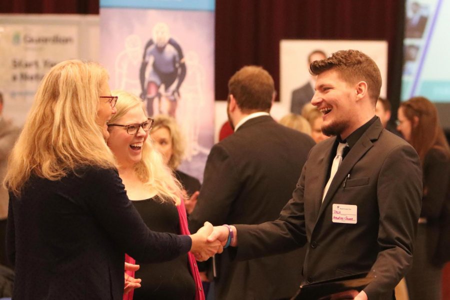 Zach Rogney shakes hands with potential employer, Jan Froelich.