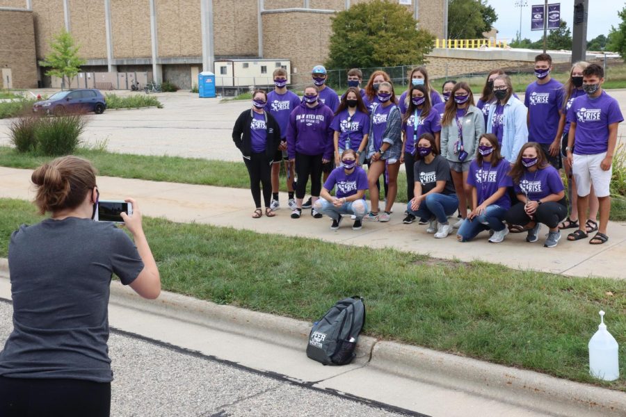 Purple Pit Crew member Katherine Reddeman takes a group photo of Peer Mentor Katie Sorensen and new students who are part of the Live and Learn, learning community, during Warhawk Welcome.