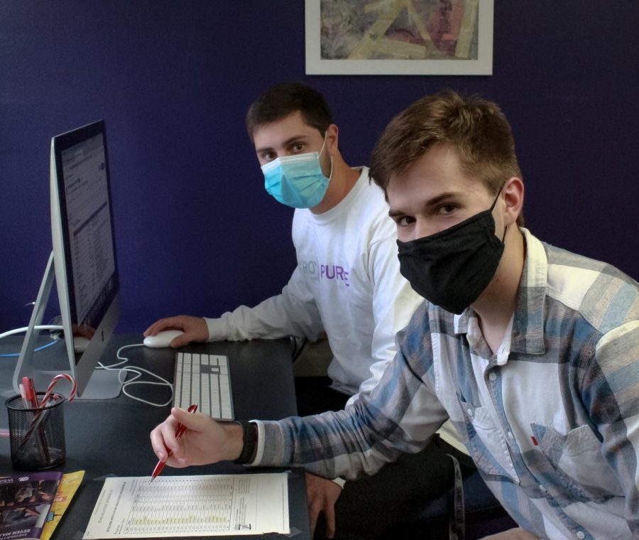 Advertising manager Ryan Piontek and assistant manager Mitchell Grinyer work out the Royal Purple budget at the office in McCutchan Hall. 