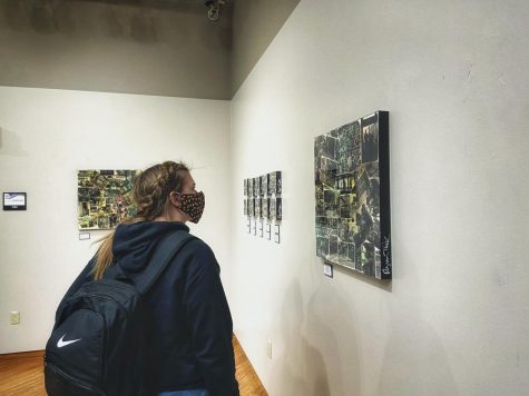 Nichole Learman stares at the Street Scenes by artist Ryan Tucker in the University Center on Campus - Kylie McCombe