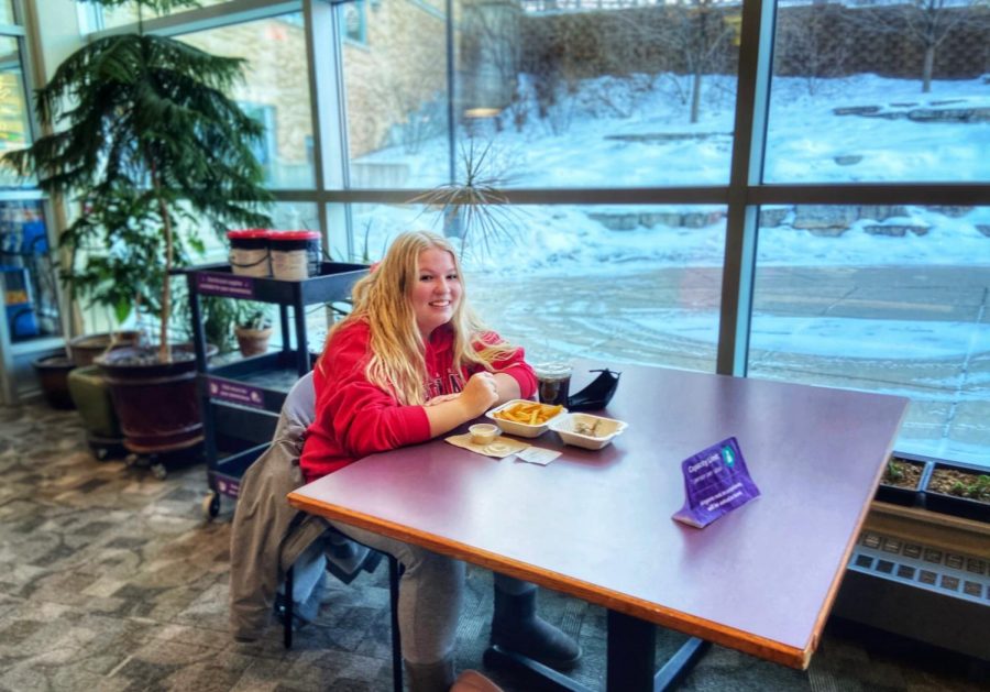 Alexus Hoelbl (pictured above)  enjoys her food while sitting socially distanced with her friends outside of Warhawk Alley located in the James R. Connor University Center on Friday, Jan 22.