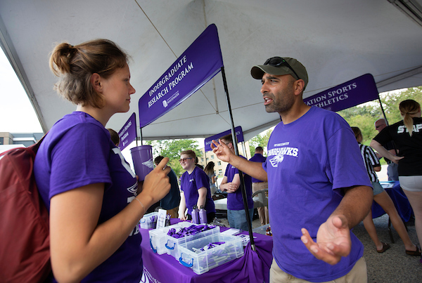 Associate professor of physics Jalal Nawash gives information to exchange student Lisa Wetzlmair of the Netherlands at the Undergraduate Research table. Games, prizes, information, music, dancing and fun are rolled into one event for new students at Hawk Fest on the UW-Whitewater campus on Monday, Sept. 2, 2019, on the day before fall classes begin. (UW-Whitewater photo/Craig Schreiner)