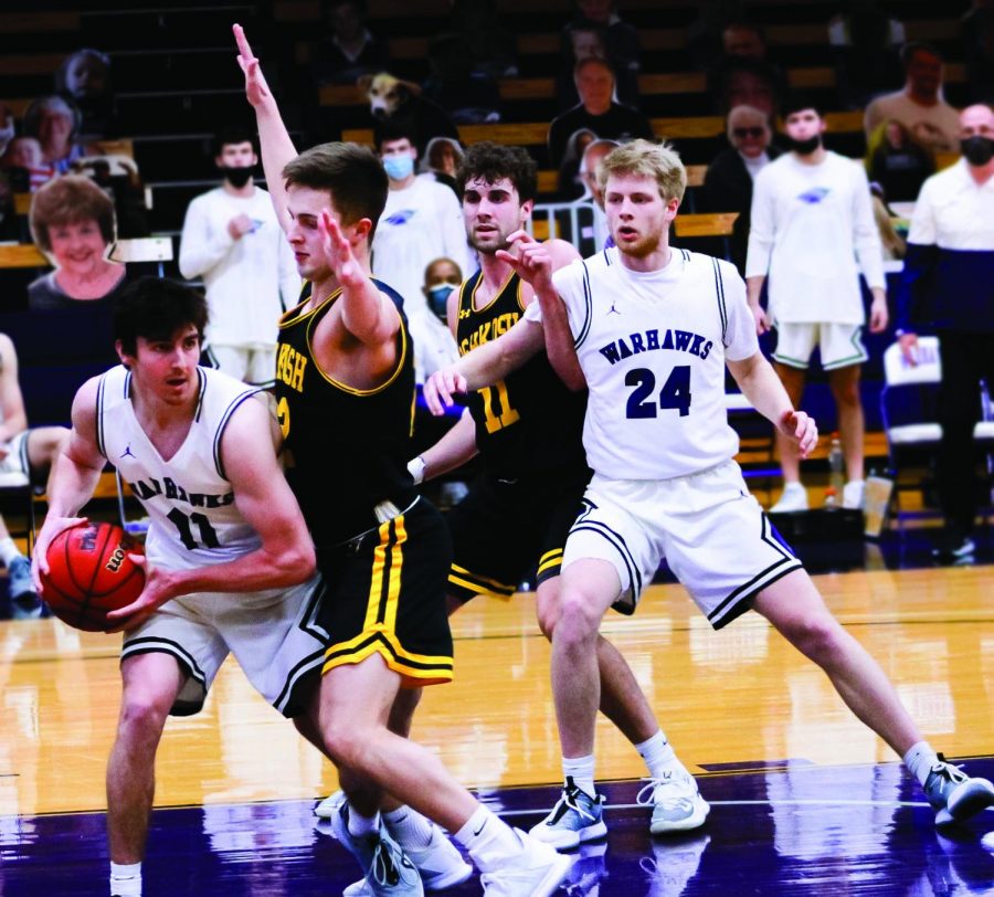 Sophomore guard Brian Conaghan (11) looks for an opportunity to pass the ball while junior forward Jack Brahm (24) blocks a UW-Oshkosh player Friday, Feb. 10. 
