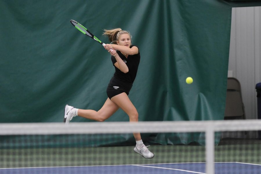 Senior Sabrina Palavra jumps in mid-air after hitting the ball during the warhawks match against
Cardinal Stritch at Lake Geneva Tennis Saturday Feb. 13.