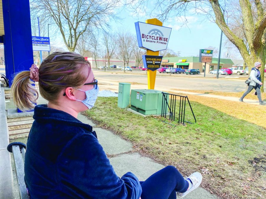 Enjoying the warmer weather that we’ve been getting, senior student Sarah Augustine sits on a bench located right outside the doors of BicycleWise & Sports Fitness.