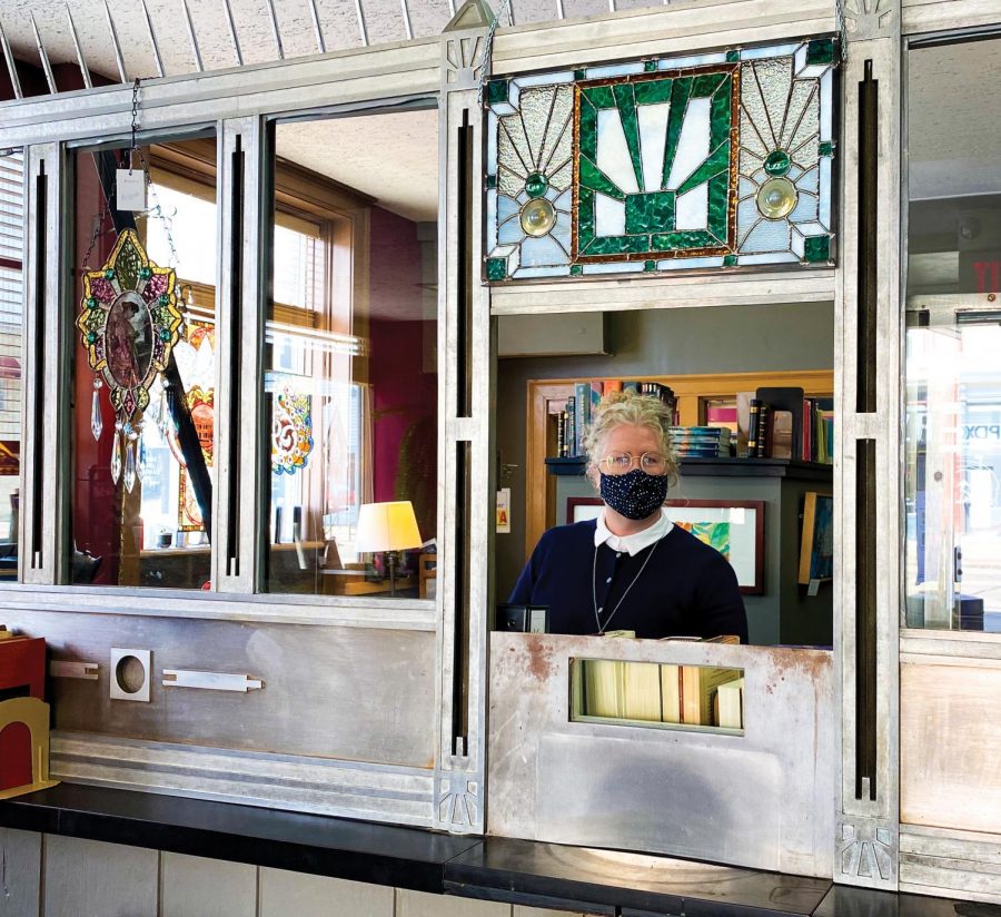 Karen Mccullogh, co-owner of The Book Teller, stands behind a bank teller window. The book and handmade products store was once one of the banks here in Whitewater! The store still has features from the old bank that was once there: the money vault, which customers can still enter to find some mystery books, and the old bank teller window.