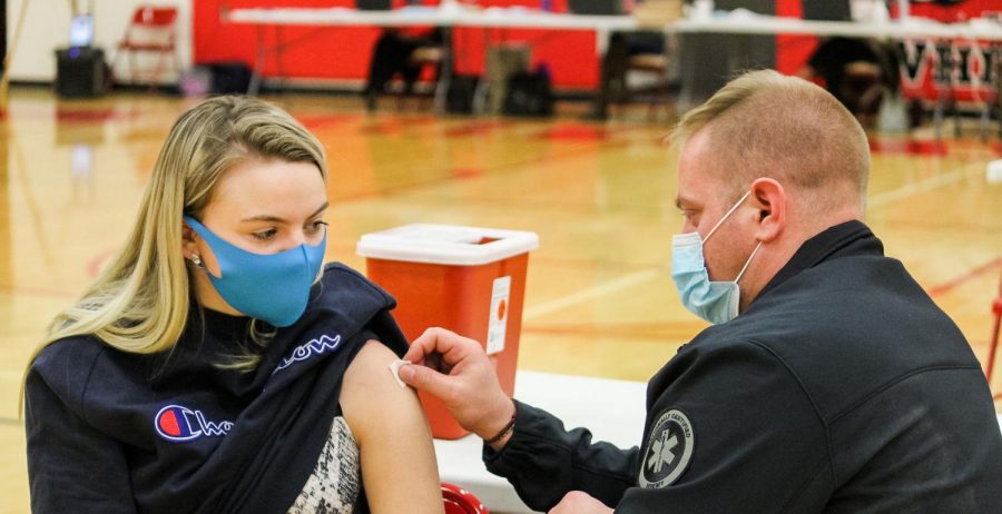 Firefighter/EMT Joshua Green helps prep Veronica Konzakova before getting her first COVID-19 shot at Whitewater High school, March 16th. 