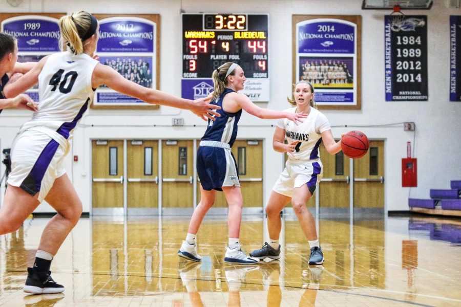 Senior guard Rebekah Schumacher (14) (right) looks to pass the ball to center Johanna Taylor (40) during the Warhawks first round game against the Blue Devils.