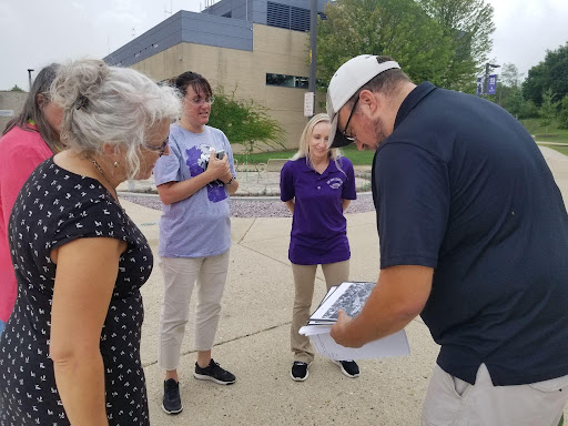 Sustainability Office Director Wes Enterline shows an intrigued staff some historical photos of The Hamilton Green, an old five-acre garden used by the university when it was originally a normal school that instructed teachers.