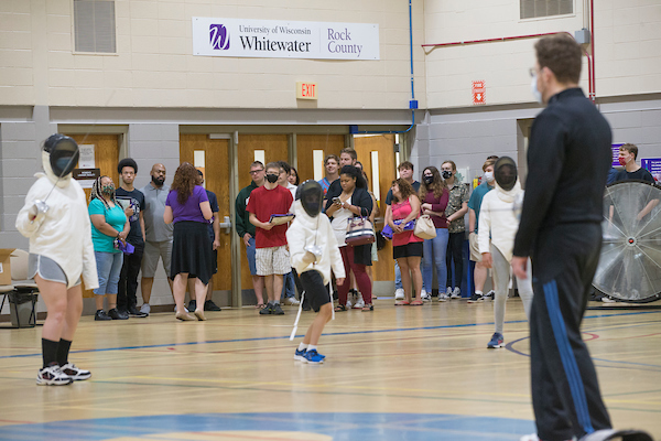 Admitted students and families, rear, tour Wells Cultural Center as a youth fencing class, taught by Senior Lecturer Brian Duckwitz is in session. Admitted students for fall and their families were welcomed to the UW-Whitewater at Rock County campus in Janesville on Tuesday, July 27, 2021. 