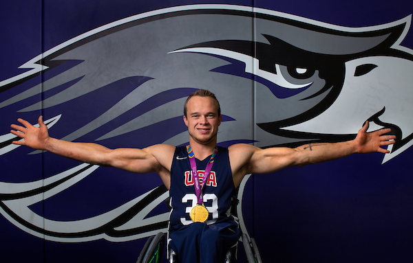 John Boie's basketball wingspan nearly equals that of a giant Warhawk emblem on a wall in Roseman Gym, where Boie practiced as a student with the UW-Whitewater Men's Wheelchair Basketball Team. Boie, who earned a BBA in human resources management in 2014 and is now an academic advisor at the university, last month won a gold medal with Team USA at the Parapan American Games in Lima, Peru, and anticipates playing in the 2020 Paralympic Games in Tokyo. (UW-Whitewater photo/Craig Schreiner)