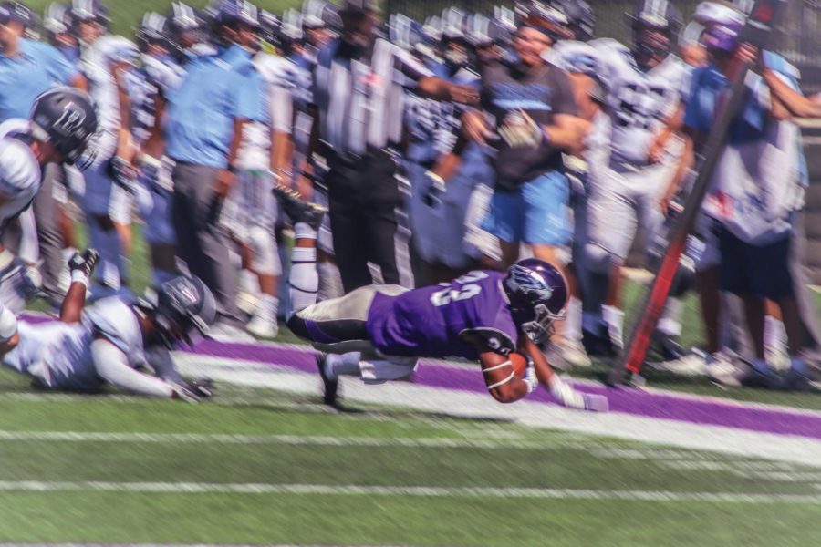 Senior Running back Alex Peete (23) plunges toward the ground in the end zone escaping the opposing team in Perkins Stadium, Saturday, Sept. 18, 2021.