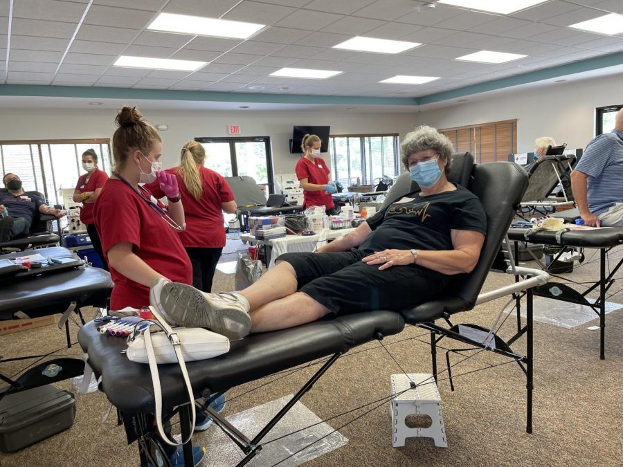 Eda Wilson, a community member donating blood with a fellow Red Cross nurse.