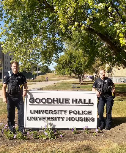Residence Hall Officers Dan Kuehl, as he stands on the left and Alison Fish, as she stands on the right, pose for a photo outside of the University Police headquarters.