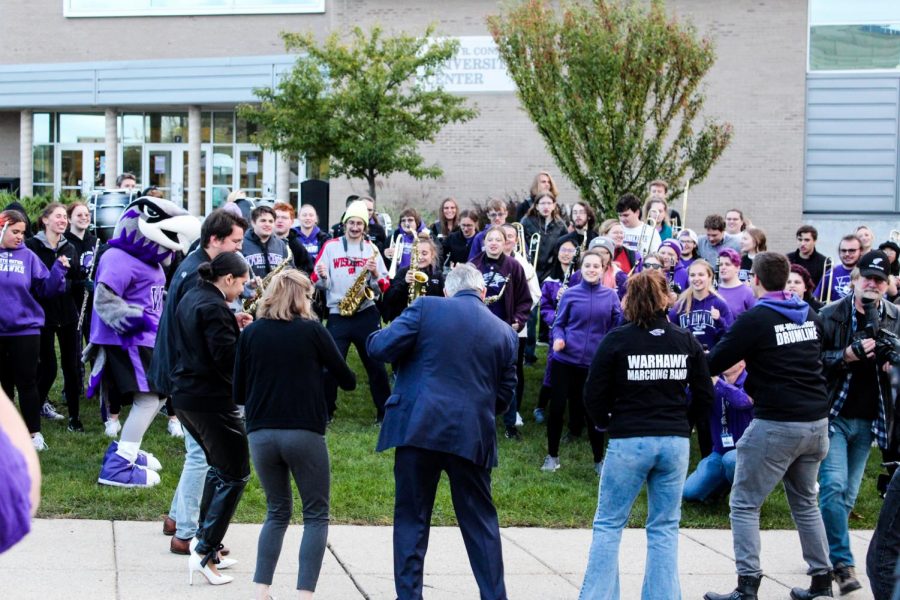 Tommy Thompson joins the University of Wisconsin Whitewater Marching Band in dancing the “Warhawk Strut” in celebration of the seventy percent vaccination rate.