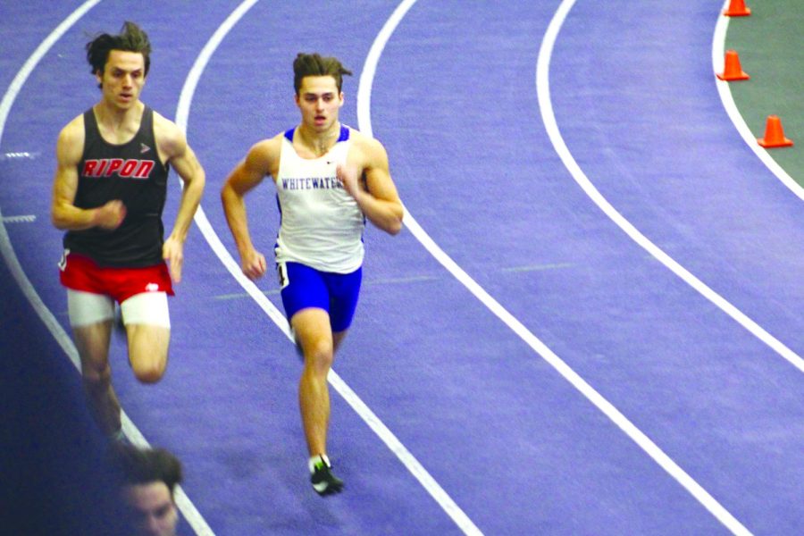 Freshman Hunter Manuel passes an opponent from Ripon during the first heat of the four hundred meter dash at the “Squig” Converse Invitational meet in Whitewater on Jan. 28, 2022.