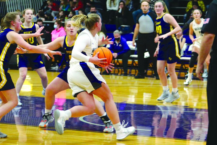 Senior guard number 14 Rebekah Schumacher makes a drive to the basket to score two points for the Warhawks against the University of Wisconsin - Stevens Point in the home game on Jan. 26, 2022.