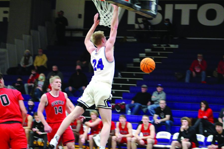 Junior forward Jask Brahm leaps to block a shot from a University of Wisconsin - River Falls opponent in their home game Feb. 5, 2022.