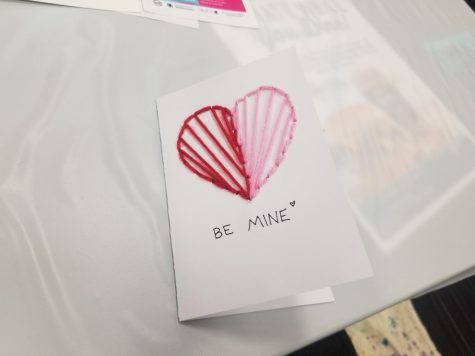  sewn-in heart Valentines day card that has “Be Mine” written on it.
