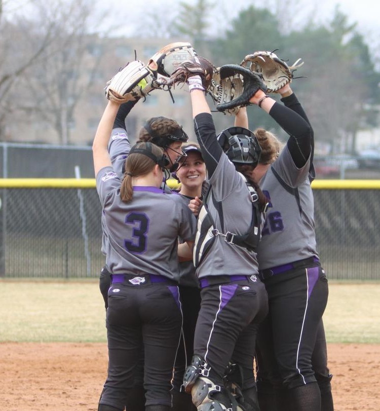 Members of the UW-Whitewater softball team huddle at the pitchers mound before the start of an inning, during the Warhawks game against the University of Chicago Mar. 27, 2021.