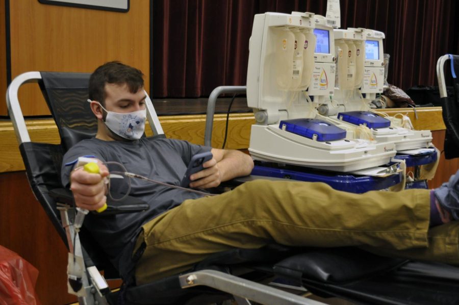 Freshman Joshua Stoughton squeezes a stress ball to maintain regular blood flow during his first donation at UW-Whitewater Tuesday, Feb. 22 in the University Center Hamilton Room.