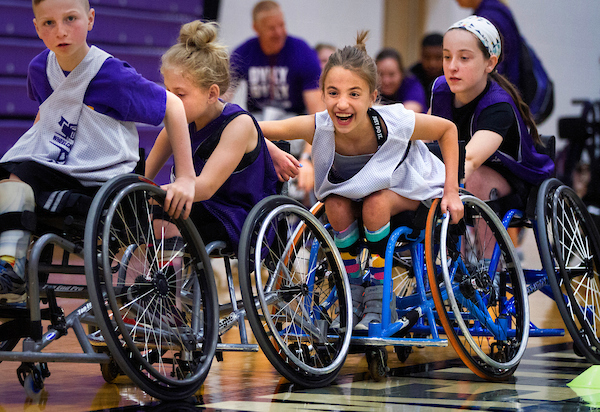 Tessa Pate, 9, third from left, enjoys the challenge of racing with a four-player team during a drill. Wheelchair basketball players of many ages come together for a week in summer to learn from premier college athletes and Paralympians at a wheelchair basketball camp at UW-Whitewater. (UW-Whitewater photo/Craig Schreiner)