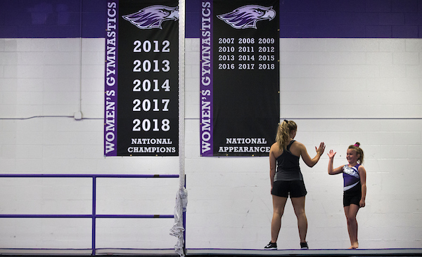 Julia Nelson, left, gives a high five to one of the campers in the Warhawks Gymnastics Camp at UW-Whitewater on Wednesday, August 8, 2018.  Julia also works in the GymHawks Gymnastics program for young gymnasts.  (UW-Whitewater photo/Craig Schreiner)