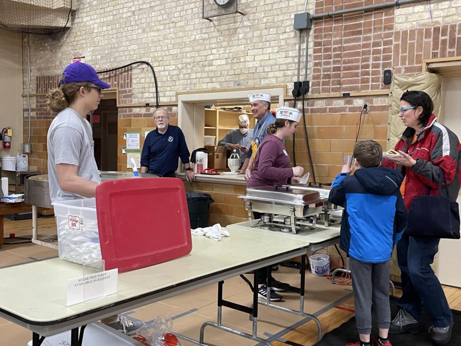Volunteers work together to make pancakes on a giant griddle and serve food to the public at the Kiwanis Pancake Breakfast Saturday, April 2, 2022. 
