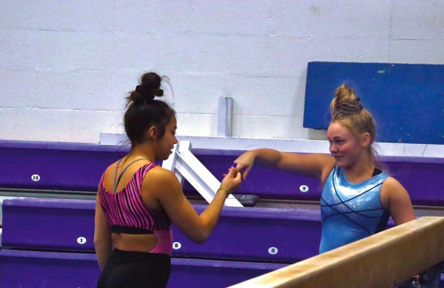 Isabella Perez Emory (left) and Halee Peters (right) encourage each other between practices with a friend handshake Thursday evening April 14, 2022.