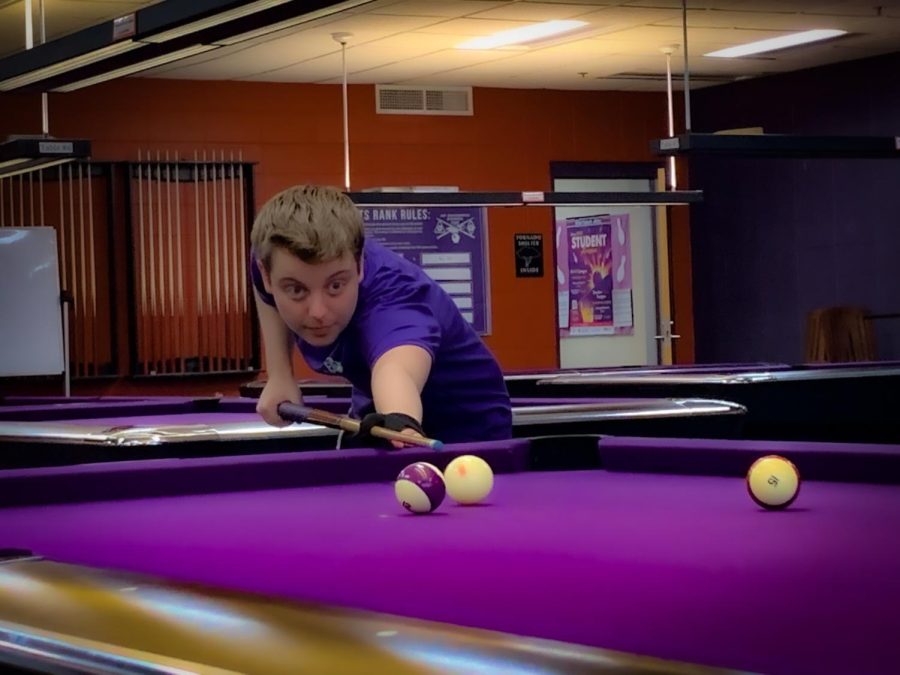 Kendal Clemetson plays very carefully while competing against others in the Billiards Club 8 Ball Tournament, in UC-Warhawk Alley.