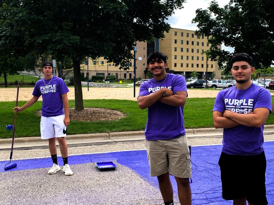 New Warhawks (pictured from left to right) Wyatt Quaintance, Lee Galarza, and friend, paint the road for Paint-it-Purple at Warhawk Drive.