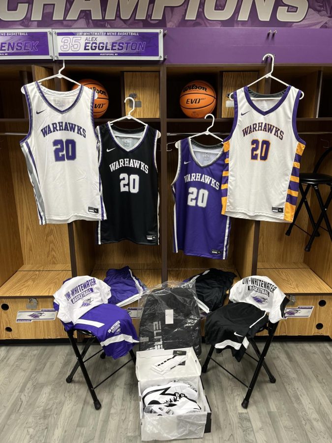The UW-Whitewater men’s basketball team displays their new uniforms. The new primary white jersey hangs on the far left. Updated black and purple jerseys hang in the middle. A retro-style jersey hangs on the far right. Photo courtesy of Pat Miller.
