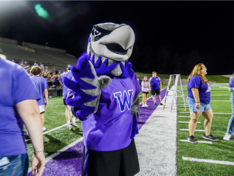 UW-Whitewaters+mascot%2C+Willie+Warhawk%2C+waves+and+welcomes+new+Warhawks+as+they+run+through+balloon+arches+at+Perkins+Stadium.