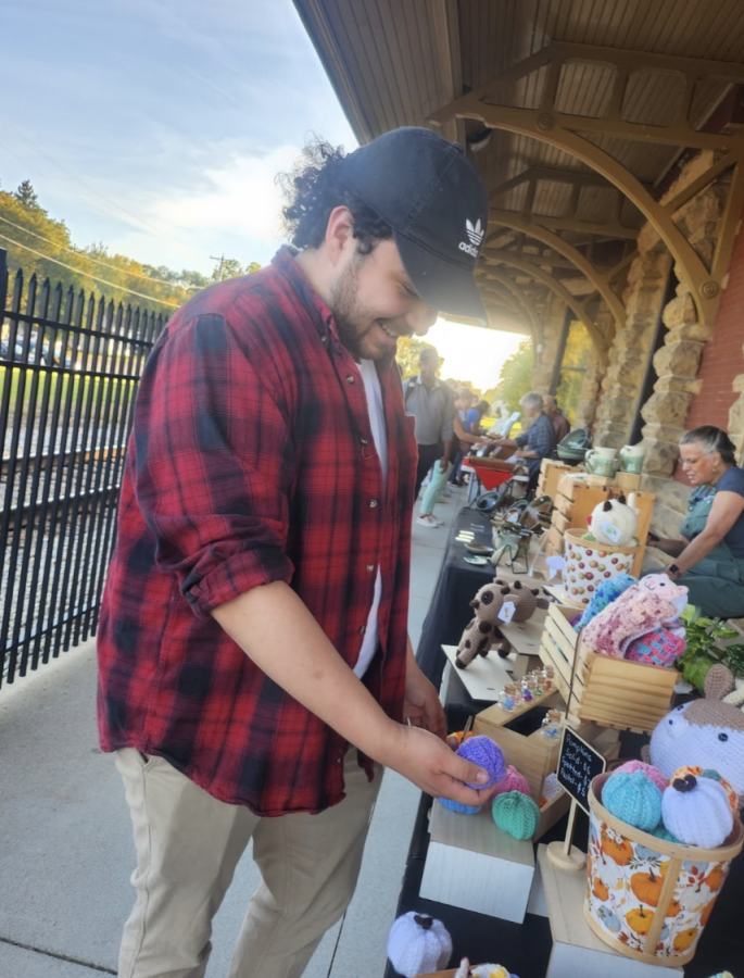 Just in time for the chilly season, UWW student Ethan Wyland tries to choose a cuddly companion from Kit’s Knits at the Whitewater City Market.
